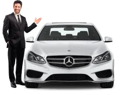 A Star Limousine executive standing in front of a Mercedes chauffeur vehicle and confidently welcoming guests