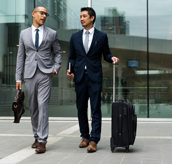 Businessmen in suits walking outside office building on a business trip